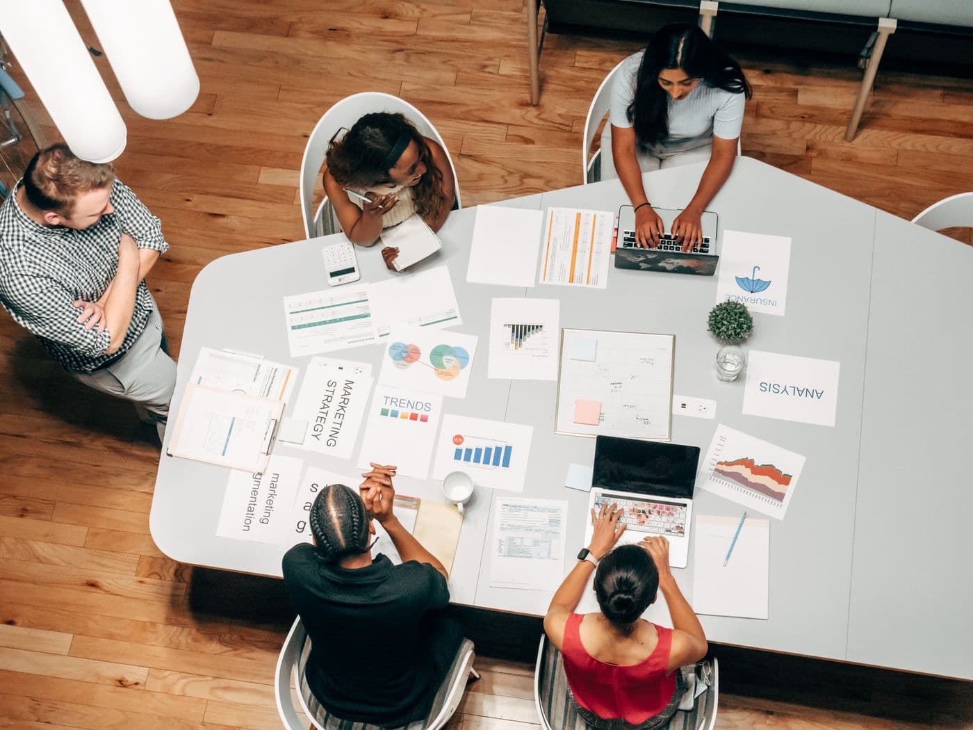 A team planning a product around a table with papers