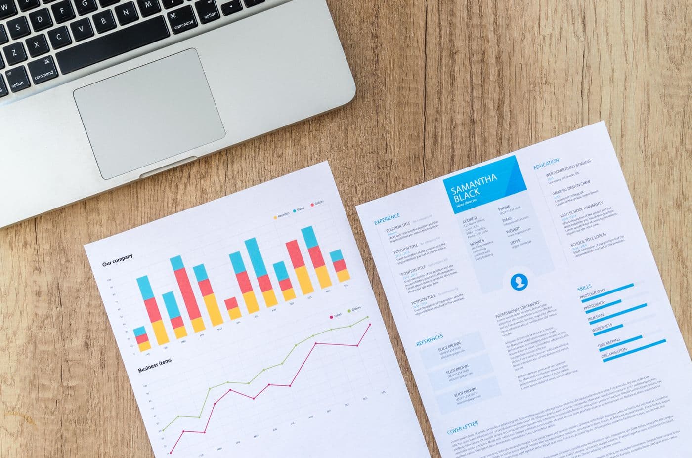 Printed reports with colorful charts on a wooden desk